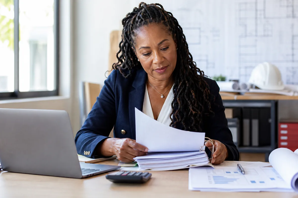 Construction business owner organizing documents for an SBA loan application.